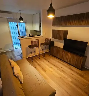 a living room with a couch and a flat screen tv at Departamento en B Gral Paz, a metros de Hospital Italiano in Cordoba