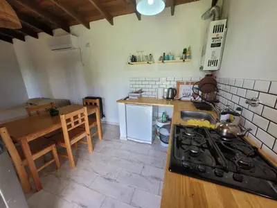a kitchen with a stove and a table in it at Villa Yacanto de Calamuchita in Villa Yacanto