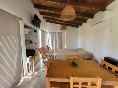 a living room with a table and a bed at Villa Yacanto de Calamuchita in Villa Yacanto