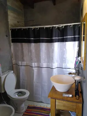 a bathroom with a toilet and a shower curtain at Villa Yacanto de Calamuchita in Villa Yacanto