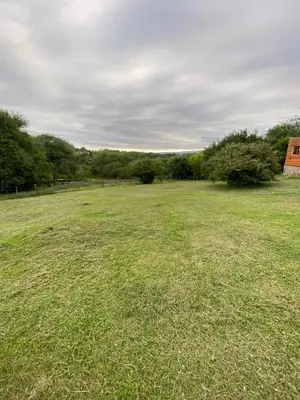 a large grass field with trees in the background at Villa Yacanto de Calamuchita in Villa Yacanto