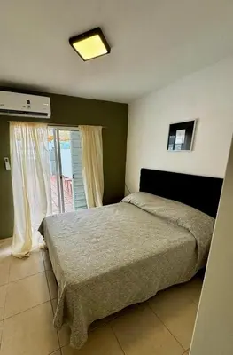 a bedroom with a large bed and a window at Departamento Peatonal de Carlos Paz con Terraza Exclusiva in Villa Carlos Paz