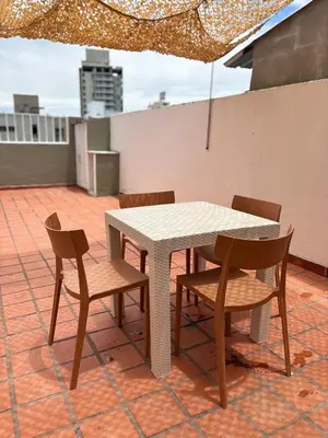 a table and chairs and an umbrella on a roof at Departamento Peatonal de Carlos Paz con Terraza Exclusiva in Villa Carlos Paz