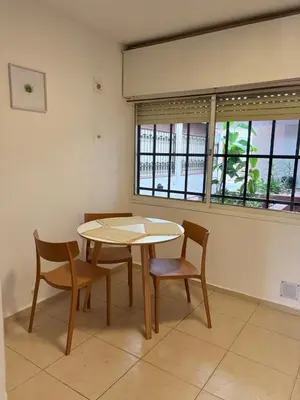 a dining room with a table and chairs and two windows at Departamento Peatonal de Carlos Paz con Terraza Exclusiva in Villa Carlos Paz