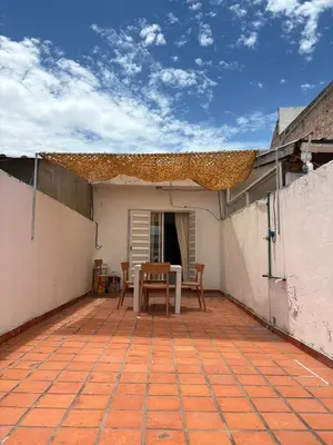 a patio with a table and chairs on a house at Departamento Peatonal de Carlos Paz con Terraza Exclusiva in Villa Carlos Paz