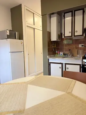 a kitchen with white cabinets and a white refrigerator at Departamento Peatonal de Carlos Paz con Terraza Exclusiva in Villa Carlos Paz