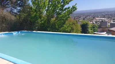 a large blue swimming pool with a view of a city at Casa con vision panoramica a 8 cuadras del centro in Villa Carlos Paz