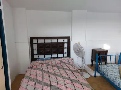 a bedroom with a bed and a fan at Casa con vision panoramica a 8 cuadras del centro in Villa Carlos Paz
