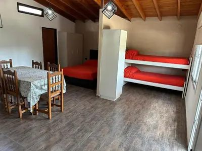 a room with a table and two bunk beds at Loft Cuesta Blanca in Cuesta Blanca