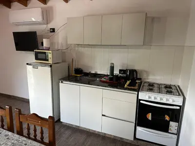 a kitchen with white cabinets and a stove top oven at Loft Cuesta Blanca in Cuesta Blanca