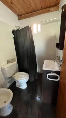 a bathroom with a toilet and a black shower curtain at El limón in Villa Yacanto