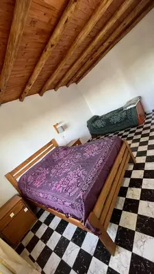 a bed in a room with a checkered floor at El limón in Villa Yacanto