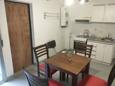 a small kitchen with a wooden table and chairs at Moderno departamento en pleno centro de Río Cuarto in Río Cuarto
