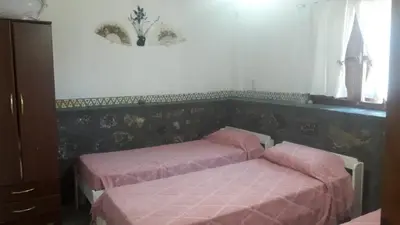 a bedroom with two beds with pink sheets at Cabañas San Gerónimo in San Jerónimo