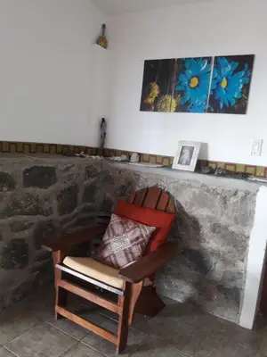 a chair sitting in front of a stone fireplace at Cabañas San Gerónimo in San Jerónimo