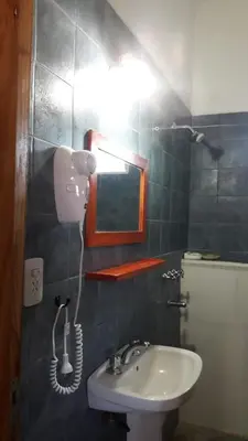 a bathroom with a sink and a light on the wall at Cabañas San Gerónimo in San Jerónimo