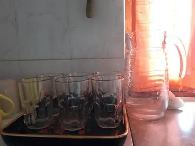 a tray with four empty glasses and a jug of water at Cabañas San Gerónimo in San Jerónimo