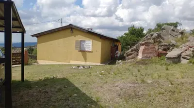 a small yellow house with a window in a yard at Cabañas San Gerónimo in San Jerónimo