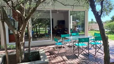 a glass house with a table and chairs at Bosquesito in Mina Clavero