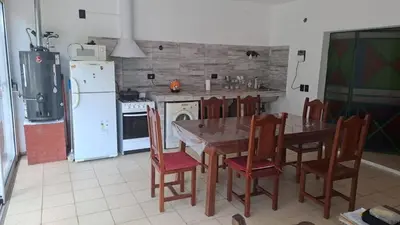 a kitchen with a table and chairs and a refrigerator at Bosquesito in Mina Clavero