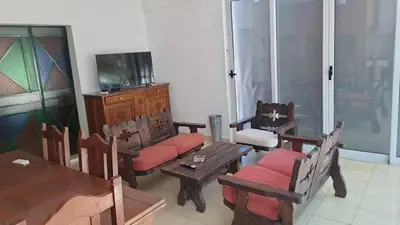 a living room with wooden furniture and a television at Bosquesito in Mina Clavero
