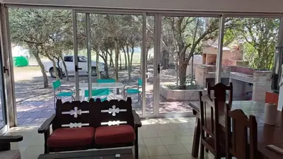 a living room with a couch in front of a window at Bosquesito in Mina Clavero