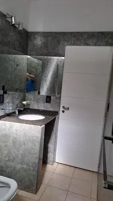 a bathroom with a white door and a sink at Bosquesito in Mina Clavero