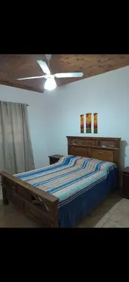 a bedroom with a bed and a ceiling fan at Mainumby in Santa Rosa de Calamuchita