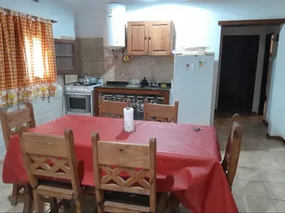 a kitchen with a table with a red table cloth at Mainumby in Santa Rosa de Calamuchita