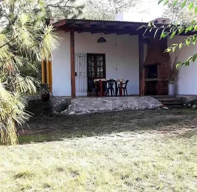 a house with a table and chairs in a yard at Mainumby in Santa Rosa de Calamuchita