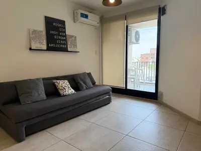 a living room with a couch and a balcony at DEPTO B GENERAL PAZ Cerca de Clínica Reina Fabiola in Cordoba
