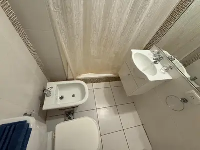 a white bathroom with a sink and a toilet at DEPTO B GENERAL PAZ Cerca de Clínica Reina Fabiola in Cordoba