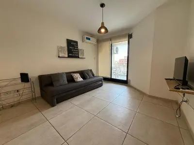 a living room with a couch and a television at DEPTO B GENERAL PAZ Cerca de Clínica Reina Fabiola in Cordoba