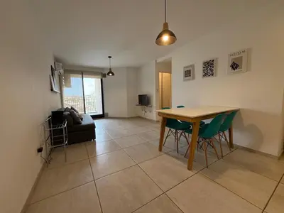 a living room with a table and green chairs at DEPTO B GENERAL PAZ Cerca de Clínica Reina Fabiola in Cordoba