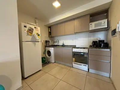 a kitchen with a refrigerator and a washer and dryer at DEPTO B GENERAL PAZ Cerca de Clínica Reina Fabiola in Cordoba