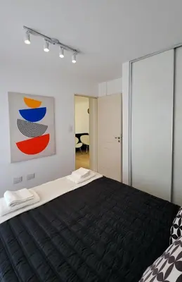a bedroom with a black bed with a painting on the wall at Moderno PENTHOUSE en Nueva in Cordoba