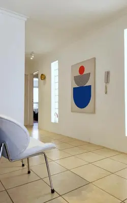 a white room with a chair and a painting on a wall at Moderno PENTHOUSE en Nueva in Cordoba