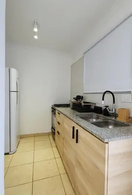 a kitchen with a sink and a refrigerator at Moderno PENTHOUSE en Nueva in Cordoba