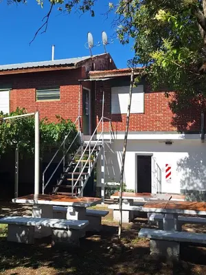 a brick building with stairs and benches in front of it at Departamentos y habitaciones en Mina Clavero in Mina Clavero