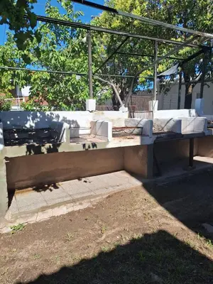 a concrete bench in a park with a picnic table at Departamentos y habitaciones en Mina Clavero in Mina Clavero