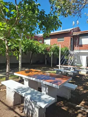 a picnic table in front of a building at Departamentos y habitaciones en Mina Clavero in Mina Clavero