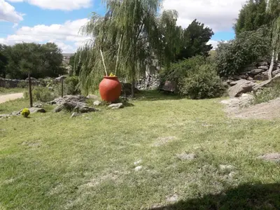 a vase sitting in the grass in a field at Cabañas San Gerónimo in San Jerónimo