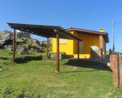 a yellow house with a roof in a yard at Cabañas San Gerónimo in San Jerónimo