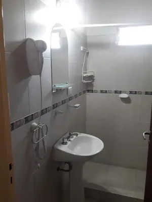 a white bathroom with a sink and a mirror at Cabañas San Gerónimo in San Jerónimo