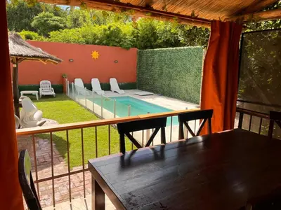 a balcony with a table and chairs and a swimming pool at Verano Paz in Villa Carlos Paz