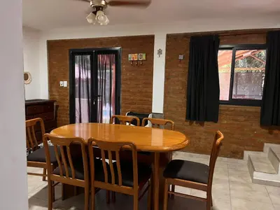 a dining room with a wooden table and chairs at Verano Paz in Villa Carlos Paz