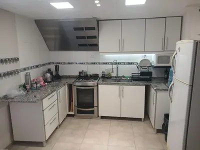 a small kitchen with white cabinets and appliances at Verano Paz in Villa Carlos Paz