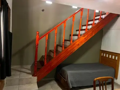 a room with a staircase with a bed and a stair case at Verano Paz in Villa Carlos Paz