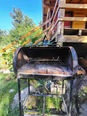 an old grill sitting outside of a house at Cabaña Aurora in Santa Rosa de Calamuchita