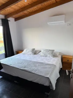 a bedroom with a bed with two pillows on it at Cabañas La Caprichosa in Villa Santa Cruz del Lago